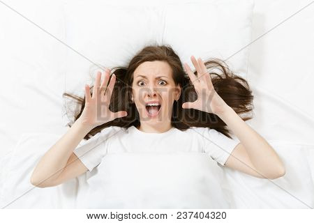 Top View Of Head Of Stress Brunette Young Woman Lying In Bed With White Sheet, Pillow, Blanket. Shoc