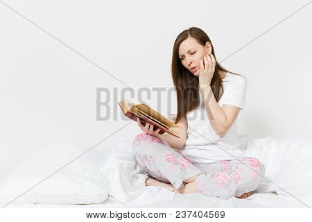 Young Calm Woman Sitting In Bed With White Sheet, Pillow, Blanket On White Background. Beauty Female