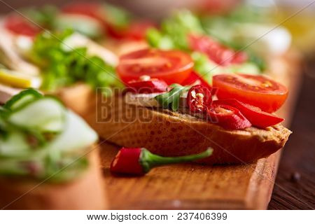 Breakfast Sandwich With Homemade Paste, Vegetables And Fresh Greenson Wooden Cutting Board Over Rust