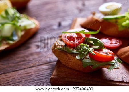 Breakfast Sandwich With Homemade Paste, Vegetables And Fresh Greenson Wooden Cutting Board Over Rust