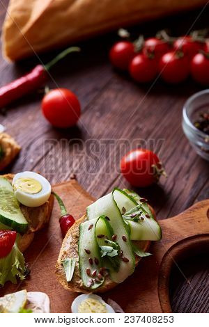Breakfast Sandwich With Homemade Paste, Vegetables And Fresh Greenson Wooden Cutting Board Over Rust