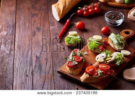 Breakfast Sandwich With Homemade Paste, Vegetables And Fresh Greenson Wooden Cutting Board Over Rust