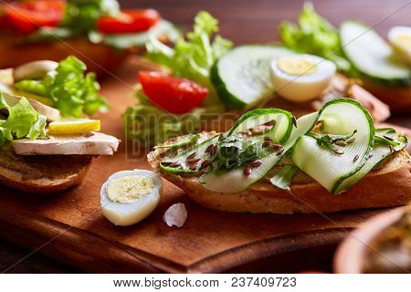 Breakfast Sandwich With Homemade Paste, Vegetables And Fresh Greenson Wooden Cutting Board Over Rust