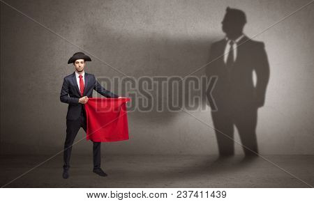 Businessman standing with red cloth on his hand and his shadow on the background