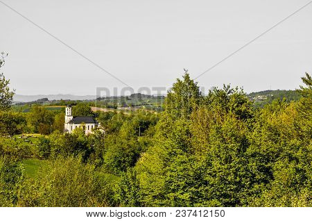 Orthodox Church Rises On A Hill Above The Forest