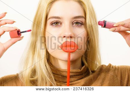 Young Adult Woman Applying Lipstick Or Lip Gloss, Getting Her Make Up Done Holding Fake Lips On Stic