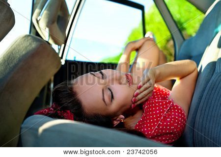 Молодая сексуальная женщина лежала в машине - pinup стиль