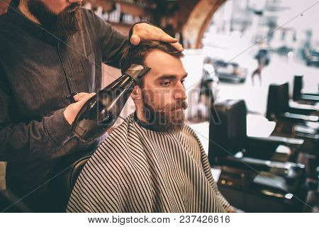 Hairdresser Is Drying The Customer's Hair With A Tair Dryer. The Customer Is Looking Down.