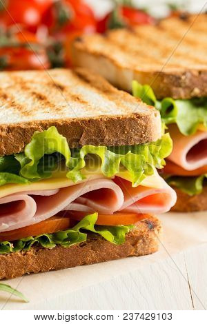 Close-up Photo Of A Club Sandwich. Sandwich With Meet, Prosciutto, Salami, Salad, Vegetables, Lettuc