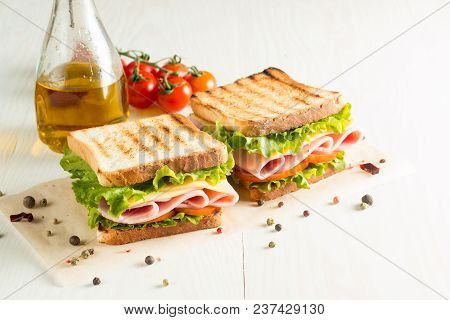 Close-up Photo Of A Club Sandwich. Sandwich With Meet, Prosciutto, Salami, Salad, Vegetables, Lettuc