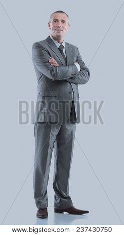 Mature business man arms folded isolated on gray.