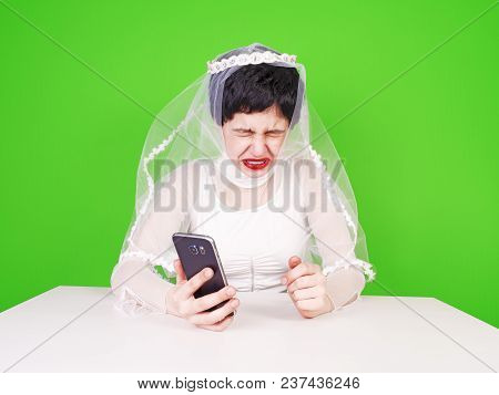Wedding Relationship Difficulties. Sad Woman With A Phone In Her Hand Is Crying. Unhappy Bride Cryin