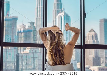 Woman Wakes Up In The Morning In An Apartment In The Downtown Area With A View Of The Skyscrapers. L