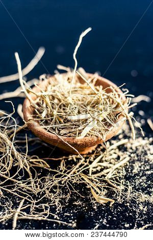 Dried Vetiver Grass Or Khus Or Chrysopogon Zizanioides Grass In A Clay Bowl On Wooden Surface.