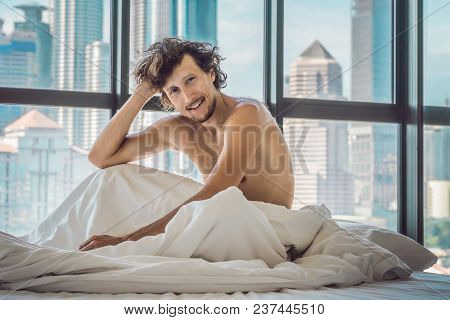 Man Wakes Up In The Morning In An Apartment In The Downtown Area With A View Of The Skyscrapers. Lif