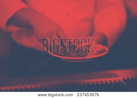 Master chef hands cooking grilled salmon fish with potatoes on a restaurant kitchen