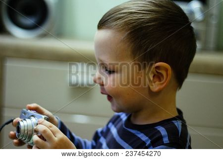 A Small Boy Holds A Camera In His Hands And Smiles, Looks At The Screen. Memories, Photography, Vide