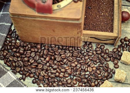 Old Coffee Grinder With Ground Coffee, Coffee Beans On A Wooden Background.