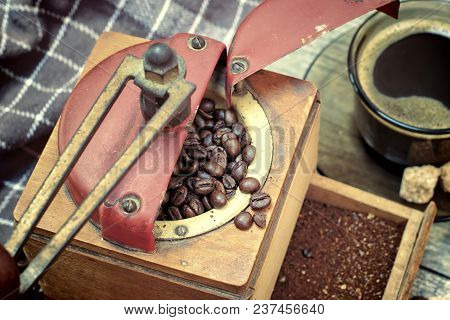 Old Coffee Grinder With Ground Coffee, Coffee Beans On A Wooden Background.