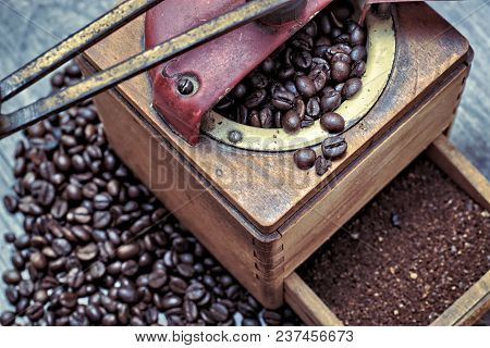 Old Coffee Grinder With Ground Coffee, Coffee Beans On A Wooden Background.