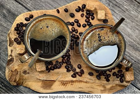 Two Cups Of Coffee,coffee Beans And Brown Lump Sugar On Wooden Background.