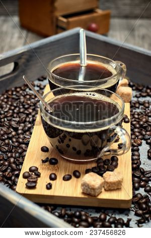 Two Cups Of Coffee,coffee Beans And Brown Lump Sugar On Wooden Background.