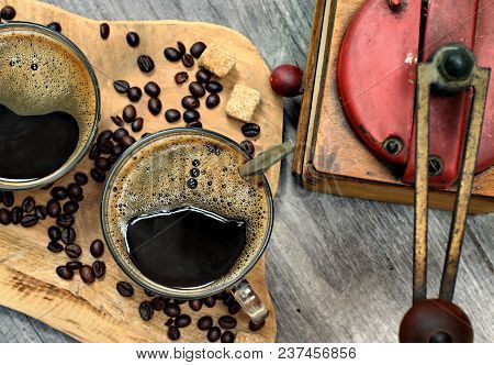 Two Cups Of Coffee,coffee Beans,brown Lump Sugar And Coffee Grinder On Wooden Background.