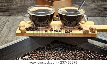 Two Cups Of Coffee,coffee Beans And Brown Lump Sugar On Wooden Background.