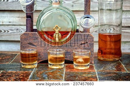 Alcohol,taste And Drink Concept-glasses With Whiskey,old Glass Barrel On Stone Table And Wooden Back