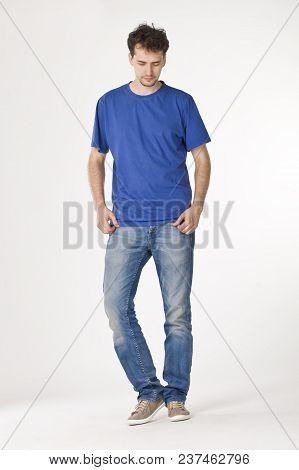Young Man In Blue T-shirt Standing And Looking Down