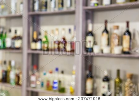 Blurred Background From Bottles With Alcohol On The Shelves In The Bar