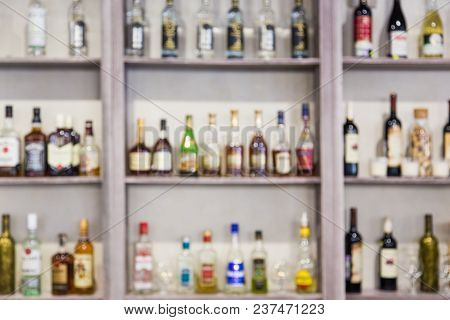 Blurred Background From Bottles With Alcohol On The Shelves In The Bar