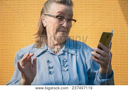 Portrait Of Old Lady, Grandmother Makes Selfie Outdoors At Sun Day. Modern Caucasian Granny Finger  