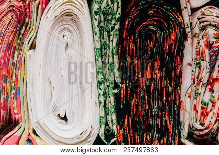 Different Types Of Fabrics Are Folded Neatly In A Row