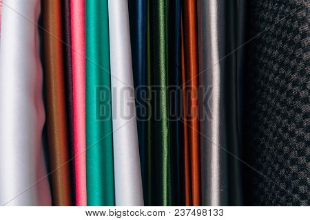 Different Types Of Fabrics Are Folded Neatly In A Row
