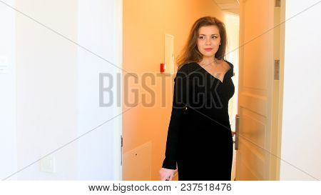 Portrait Of Elegant Businesswoman In Black Dress Enetering Hotel Room