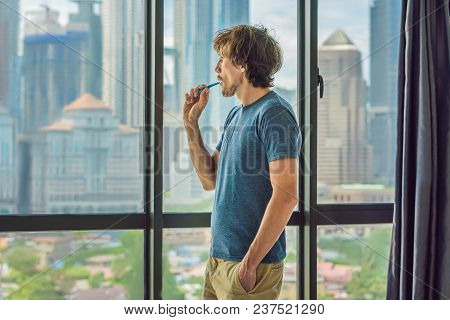 Young Man Brushing His Teeth In His Bathroom.