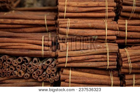 Cinnamon herbal sticks on tied rolls. Canella natural brown aromatic spice background, top view,