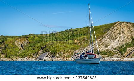 Durdle Door, Dorset, England - 16 July, 2016 : A Yacht Anchored At Lulworth Cove Near Durdle Door On