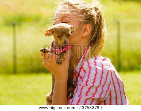 Woman Playing With Little Pinscher Ratter Prazsky Krysarik Crossbreed Hugging Small Dog Outside On G