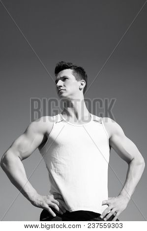 Athlete In Green Tshirt On Sunny Day. Man Bodybuilder Posing On Blue Sky. Workout And Training. Spor