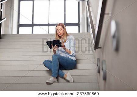technology, business and corporate concept - woman or student with tablet pc computer sitting on stairs