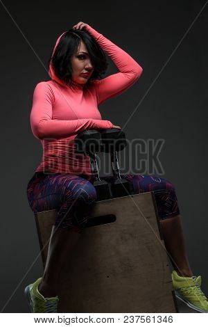 Attractive Fitness Woman In Sportswear Posing With Dumbells In Sudio On Grey Background