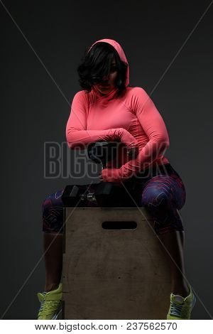 Attractive Fitness Woman In Sportswear Posing With Dumbells In Sudio On Grey Background