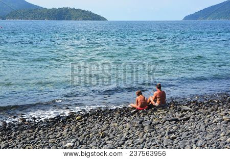 Tourists Sit On The Beautiful Rocky Beach, Koh Hin Ngam , Tarutao Marine National Park In Satun Prov