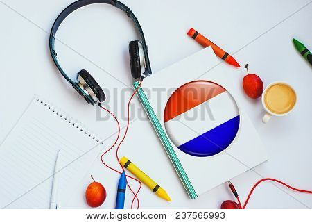 The Book With Dutch Flag And Headphones. Concept Of Dutch Learning Through Audio Courses