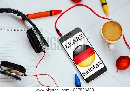 Smartphone With German Flag And Headphones. Concept Of German Learning Through Audio Courses