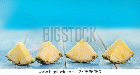 Spring Or Summer Concept : Close Up Patter Of Many Pieces Of Yellow Pineapple  On Blue Wooden Table 