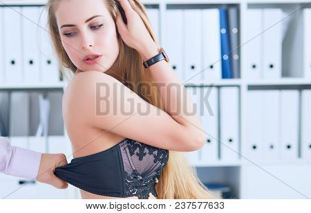 Man's Hand Pulls Bra Out Of The Beauitiful Secretary In Office Background. Flirt Or Harassment Conce
