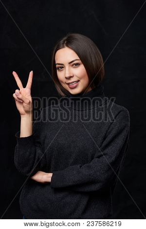 Hand Counting - Two Fingers. Smiling Woman In Grey Turtleneck Sweater Over Dark Background Showing T